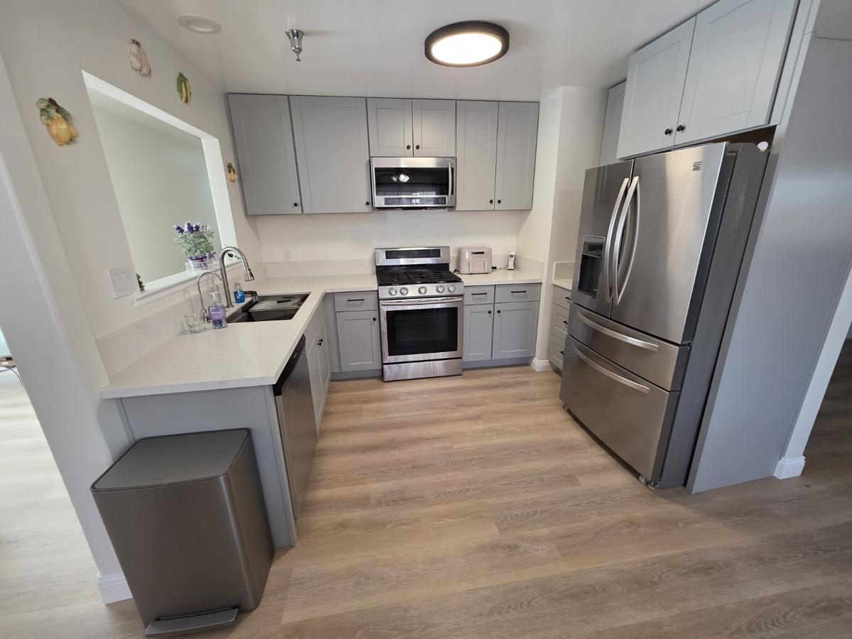 The facility kitchen with gray shaker cabinets, quartz counters and stainless appliances