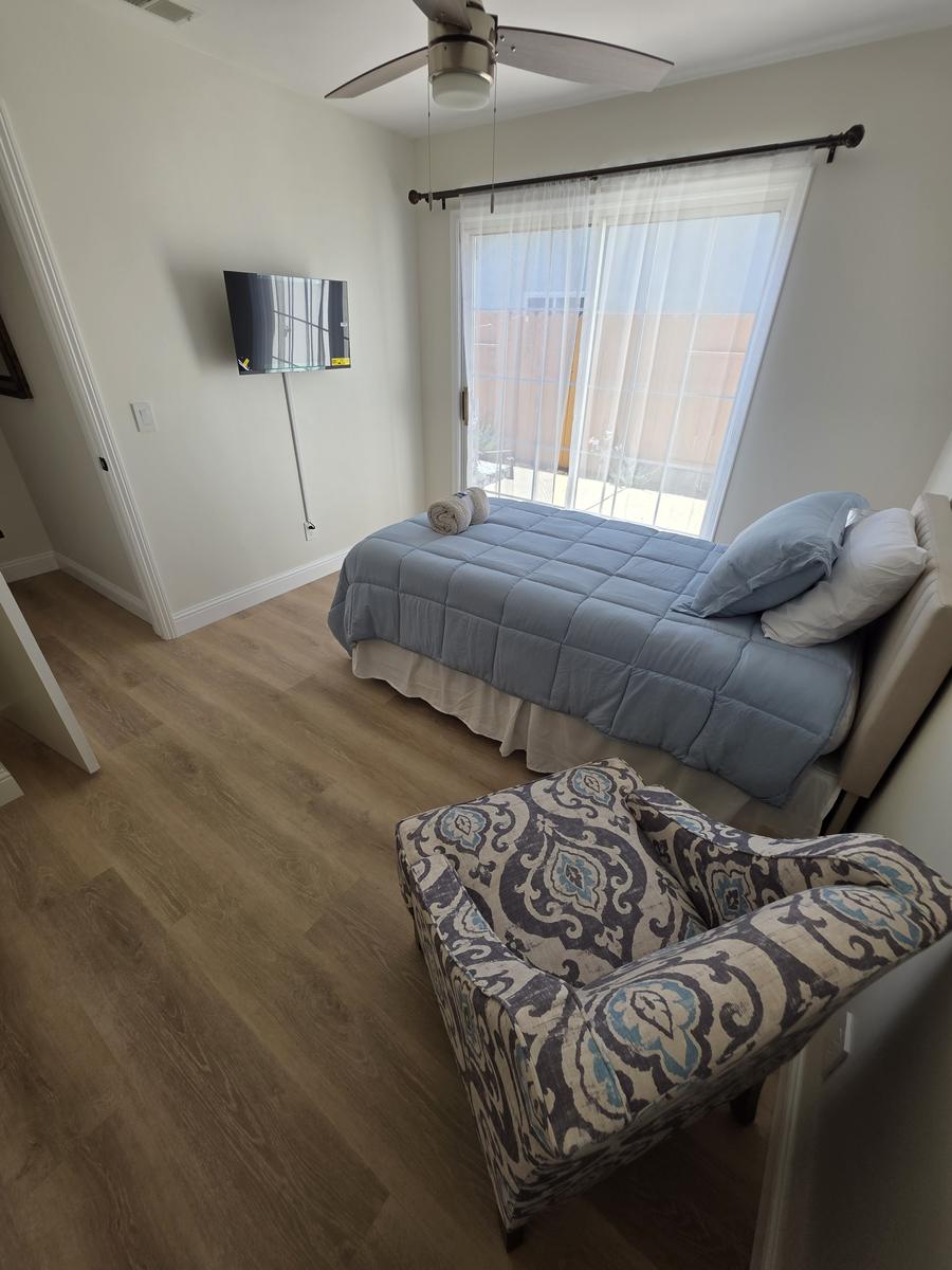 Private bedroom with sliding door to the garden, ceiling fan and television